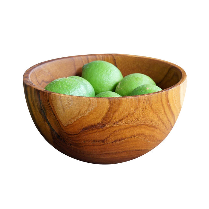 Side view of Rico & Plato chico teak bowl with limes inside displayed on a white background