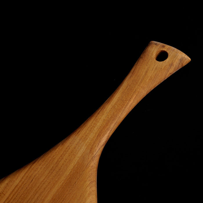 Close up of handle of the teak cutting board/serving platter displayed on a black background