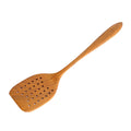 Top view of Rico & Plato emanuel teak spatula with air holes displayed on a white background