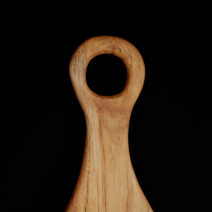 Close up of handle of Rico & Plato epazote teak cutting board serving platter displayed on a black background