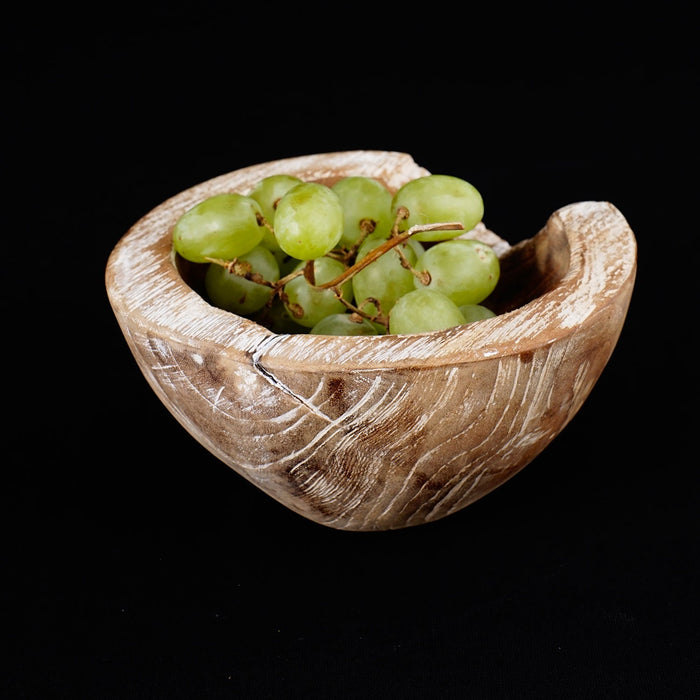Small teak bowl with whitewash exterior with grapes inside displayed on a black background