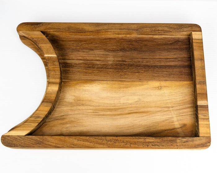 Bottom view of a teak chopping board with the raised platform with a cutout section for a plate on a white background