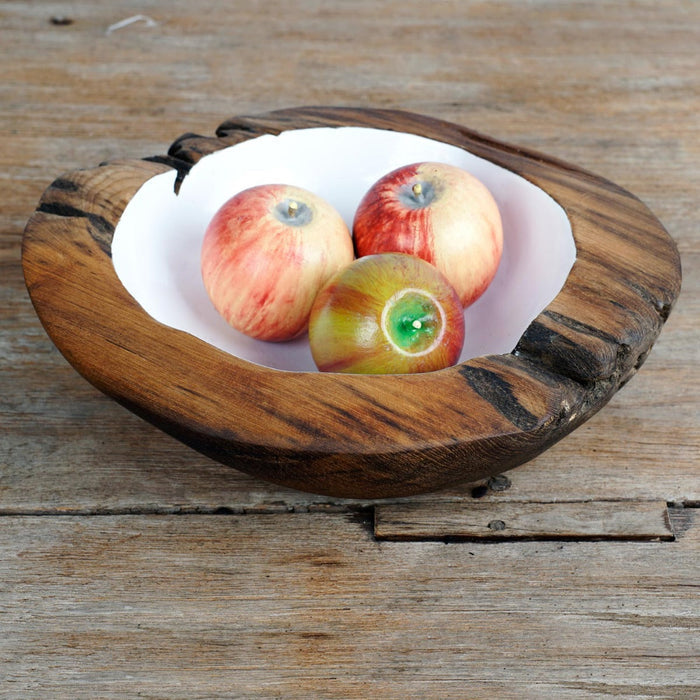 Large teak bowl with white interior filled with red apples displayed on a wooden surface
