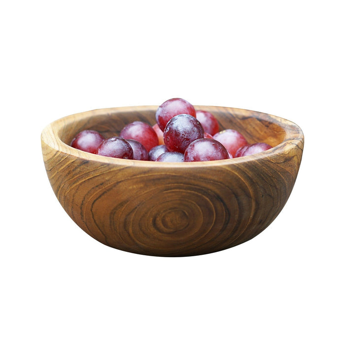 Side view of small teak bowl filled with grapes displayed on a white background