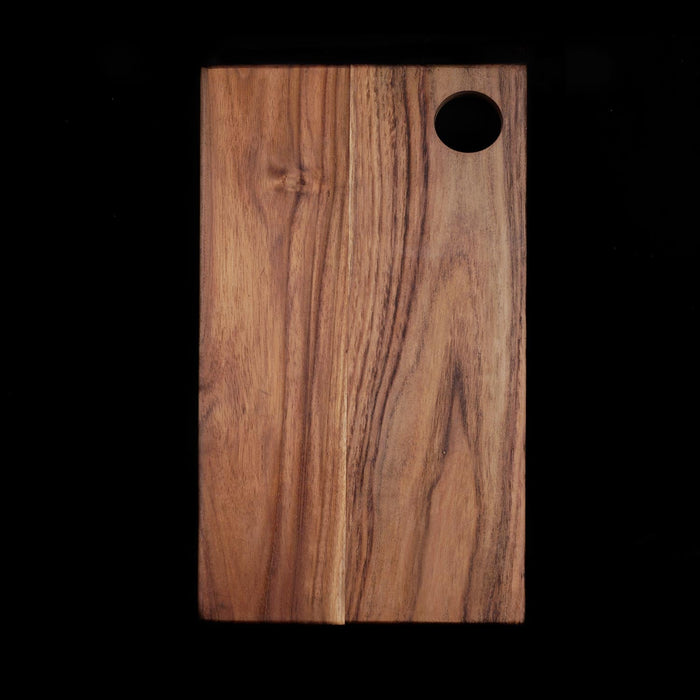 Rectangle shaped teak cutting board/serving platter displayed vertically on a black background