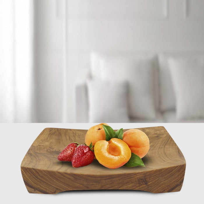 Rico & Plato mick teak serving tray with strawberries and peaches on the serving tray displayed on a white countertop in a living room setting