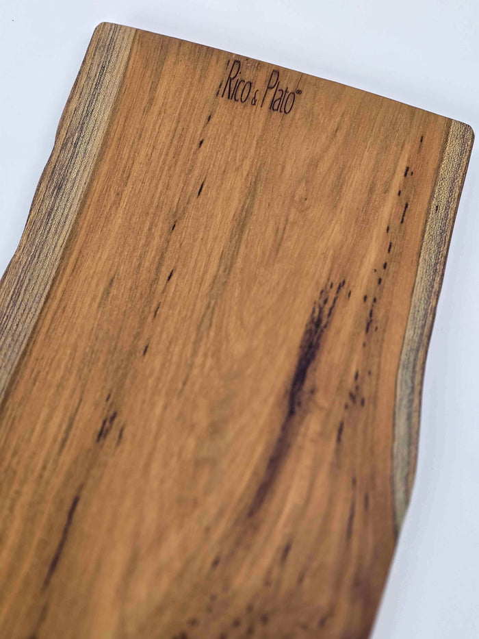 Wooden cutting board with 'Rico & Plato' branding on a white background