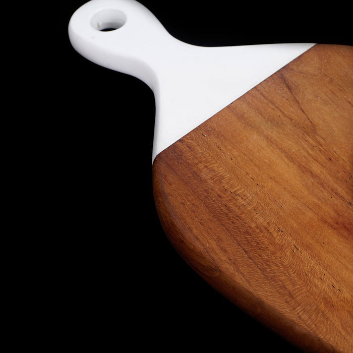 Close up of white handle of teak cutting board displayed on a black background