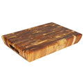 End grain teak cutting board with carved handles displayed on a white background