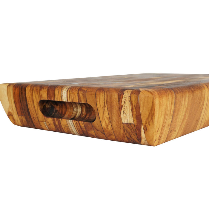 Close up of carved out handle of rectangular end grain teak cutting board displayed on a white background