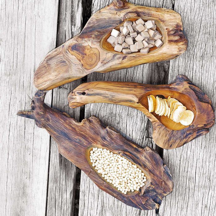 Top view of three teak bowl with natural texture filled with assortment of food displayed on  a wooden surface