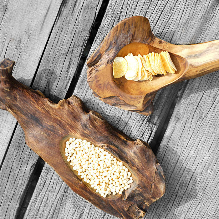 Two teak bowl with natural texture filled with chips and white balls displayed on a wooden surface