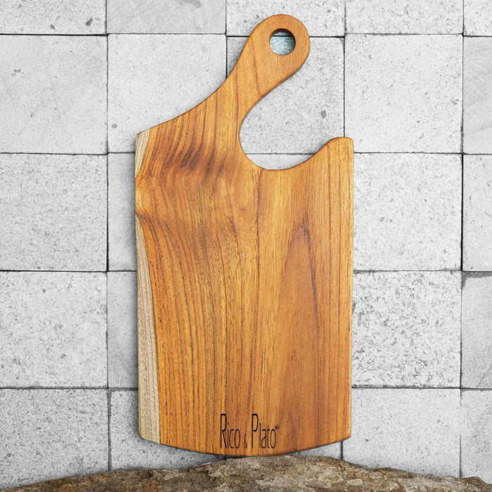 Teak cutting board with natural teak handle and Rico & Plato logo displayed vertically on a tiled background