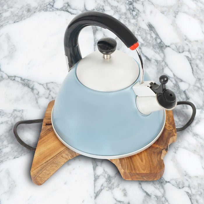 A teak wood trivet with curved steel handles, with a blue and white kettle on top of it, placed on a marble surface.