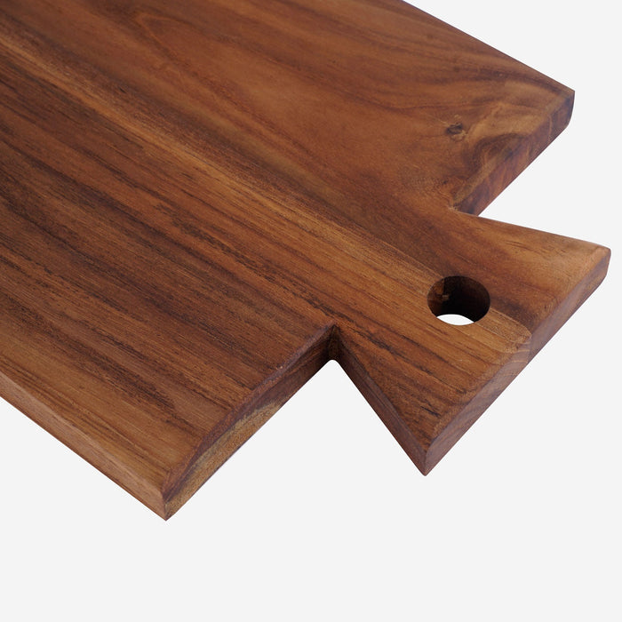 Close up of handle of teak cutting board/serving platter displayed on a white background