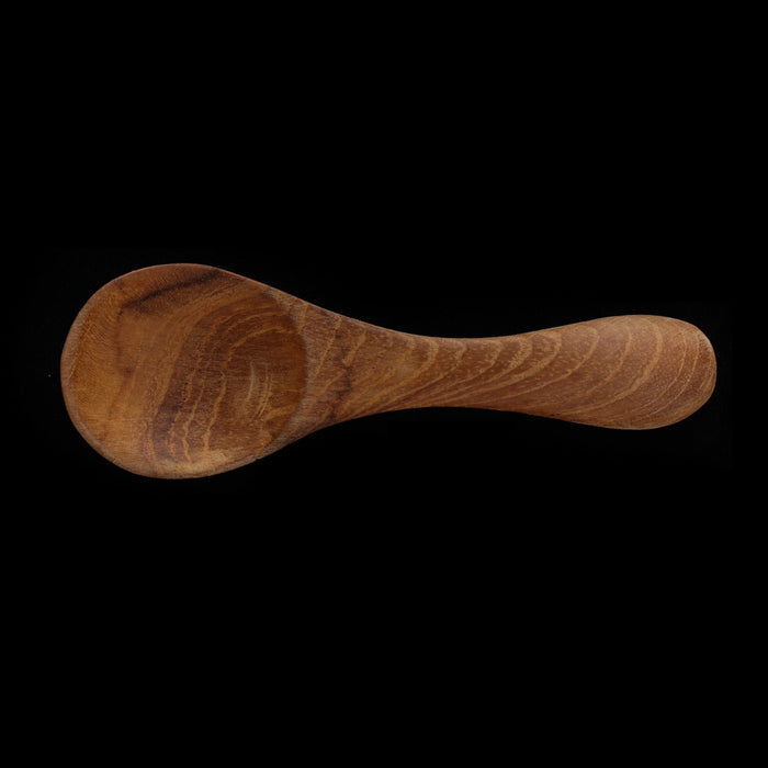 Top view of small baby spoon displayed horizontally on a black background