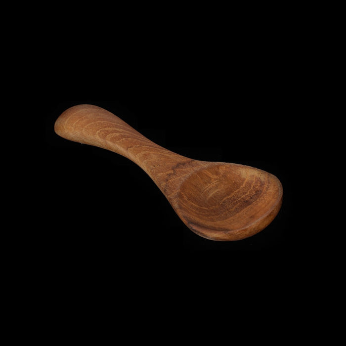 Small wooden baby spoon displayed on a black background