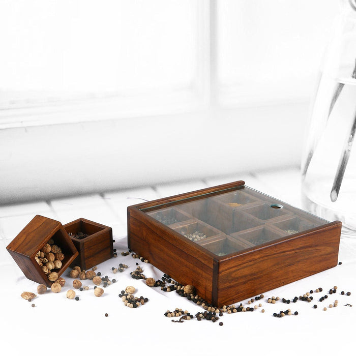 Rico & Plato teak spice box with spices inside and two small spice boxes on the side with spices inside displayed on a table with a white table cloth