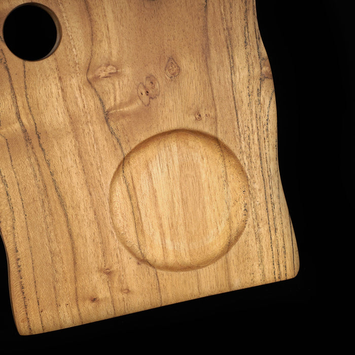 Close up of the indent for the cup holder on the teak coffee cup server displayed on a black background