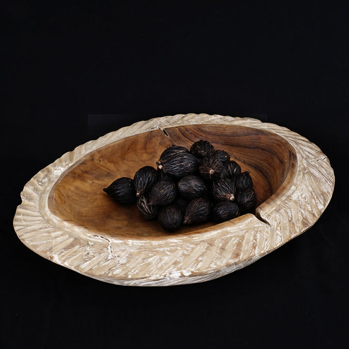 Teak bowl with whitewashed edge with dark shells displayed on a black background