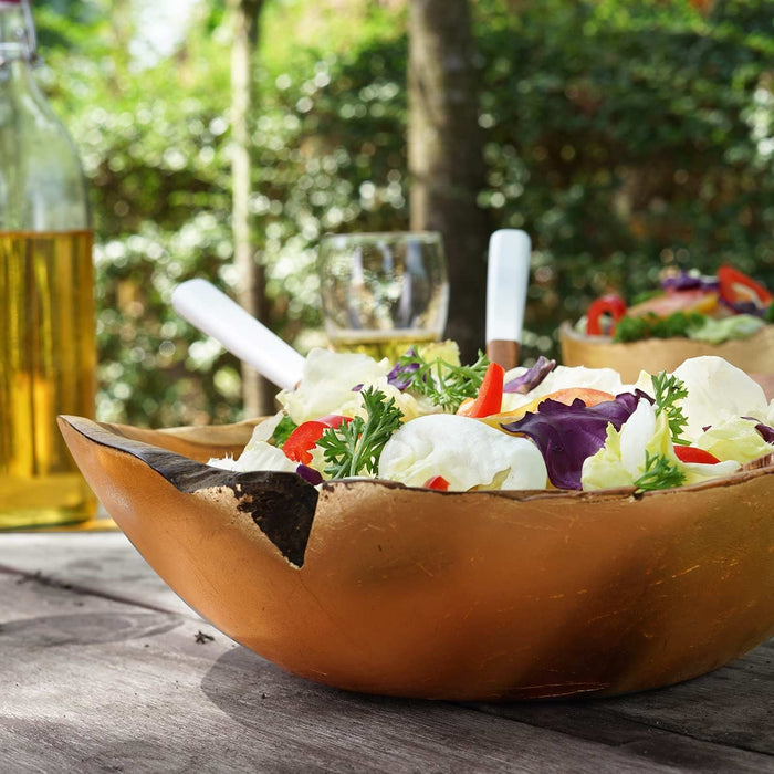 Rico & Plato umbria teak salad fruit bowl with a salad inside displayed outside on a wooden surface