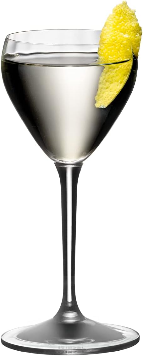 Riedel drink specific glassware Nick & Nora with white liquid inside and a lemon peel on a white background