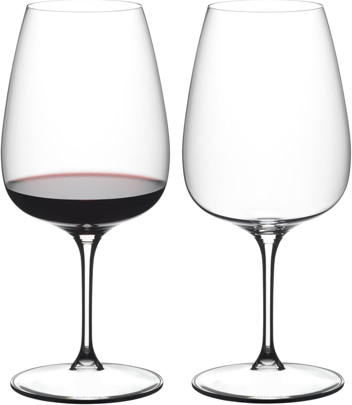 Two wine glasses, one filled with red wine, on a white background