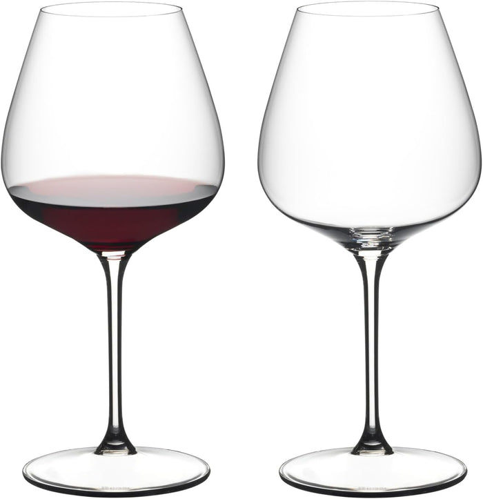 Two wine glasses, one filled with red wine, on a white background