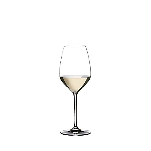A clear Riedel Riesling wine glass with a long stem and a round bowl with white wine inside on a white background