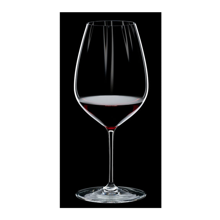 Riedel performance cabernet merlot glass with red wine inside on a black and white background