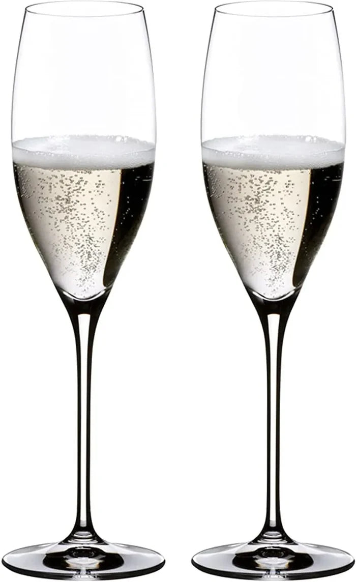Two clear champagne flutes filled with sparkling champagne, shown side by side on a plain white background.