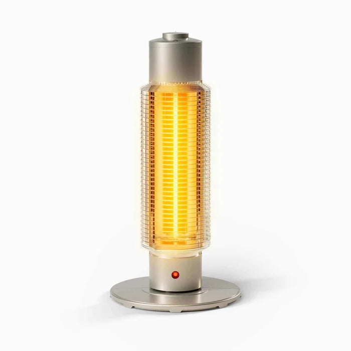A modern cylindrical electric heater with a glowing orange-yellow filament inside a clear ribbed glass body, set on a round brushed-metal base against a clean white background.