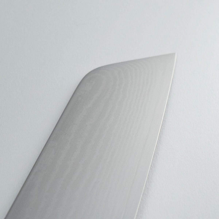 Close up of top of blade of Shun Classic Master Utility 6.5″ displayed on a white background