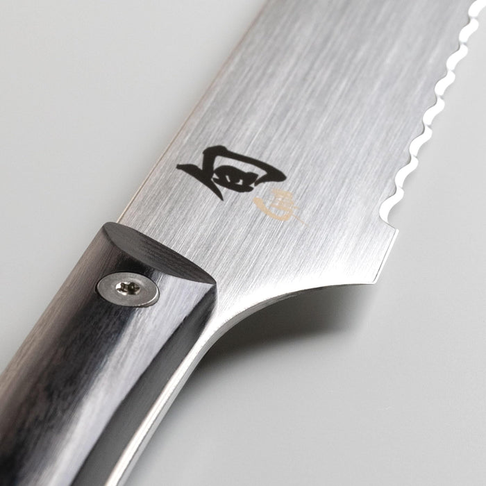 Close up of the hilt of Shun read knife on a light grey background