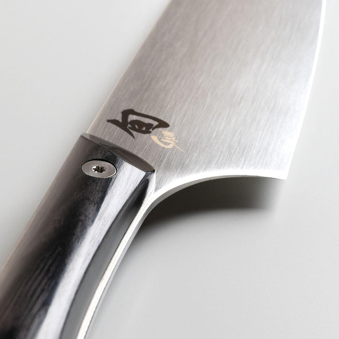Close up of the hilt of a Shun santoku knife on a white background