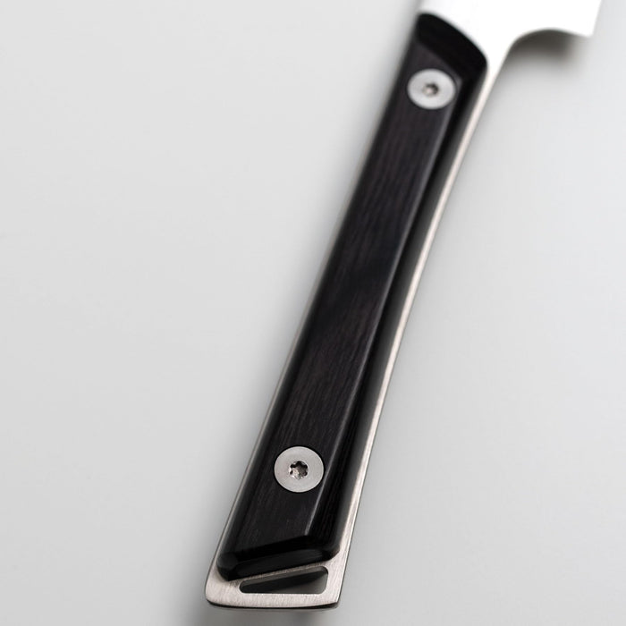 Close up of the ebony handle of a Shun utility knife on a white background