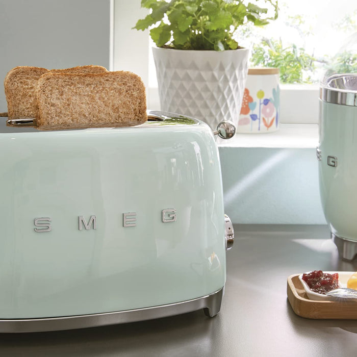 Vintage-style mint green toaster with two slices of toast, placed on a kitchen counter.