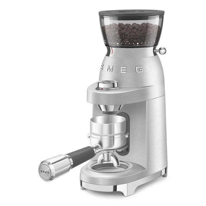 A SMEG 50's Retro Style Electric Espresso Coffee Grinder in silver color, featuring a conical burr mill and a digital display.