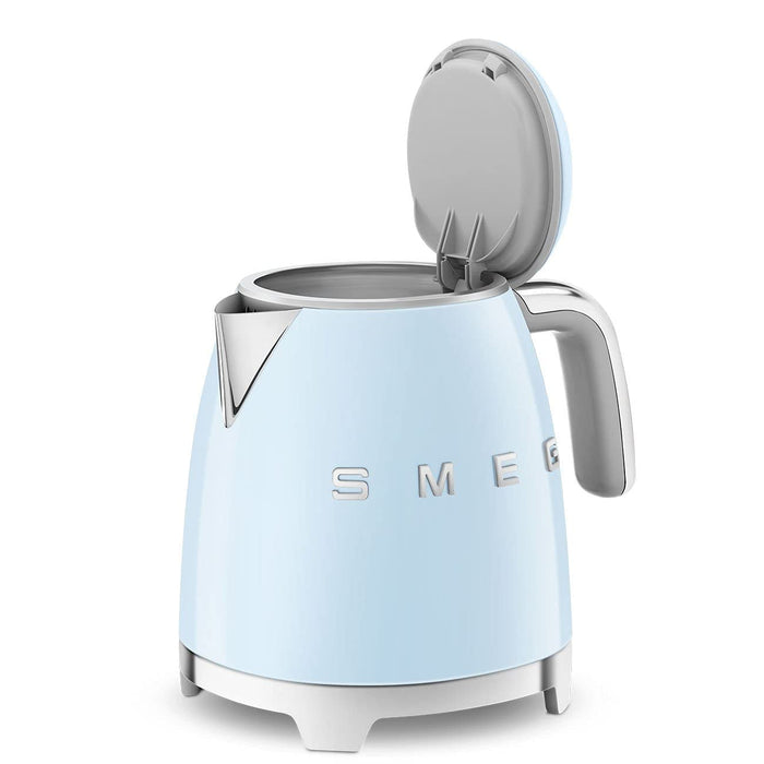 Light blue Smeg kettle with silver accents and lid open on a white background
