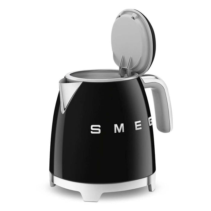Black 1.7 liter Smeg 50s retro style electric mini kettle with lid open displayed on a white background