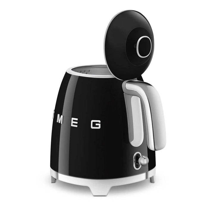 Black 1.7 liter Smeg 50s retro style electric mini kettle with power switch and lid open displayed on a white background