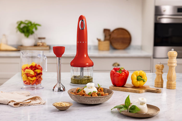 Red kitchen blender on a counter with ingredients and utensils in a kitchen setting