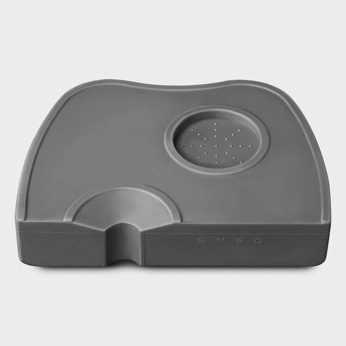 Grey Smeg tamper and portafilter holder on a white background