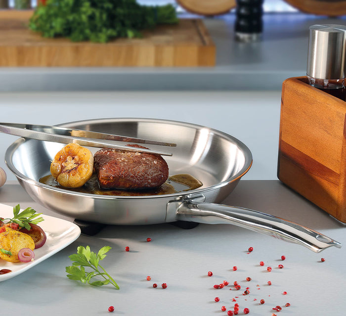 Stainless Steel frying pan with a cooked steak displayed in a kitchen setting