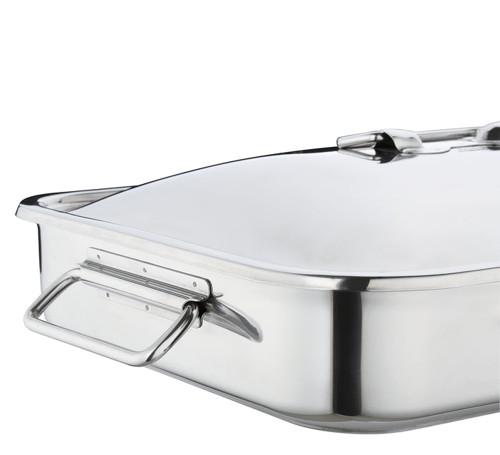 Close up of handle of stainless steel roasting pan with lid on a white background