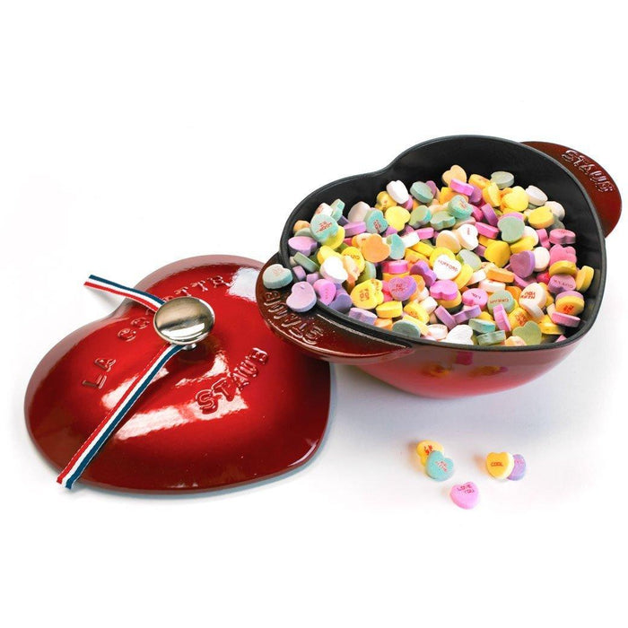 Staub Cast Iron 1.75-qt Heart Cocotte - Cherry with candy hearts inside and lid on the side displayed on a white background