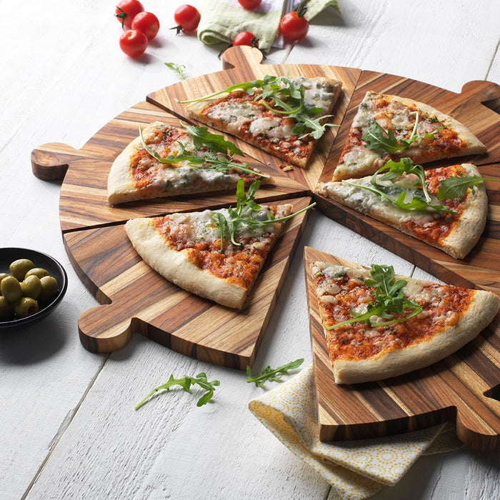 TeakHaus Cutting Boards Proteak Antipasto and Pizza Serving Platter with pizza next to olives and tomatoes on a wooden surface