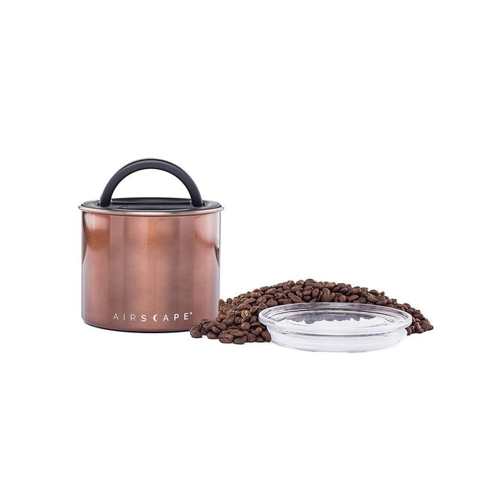 Copper-colored coffee canister with lid, coffee beans, and a clear container on a white background