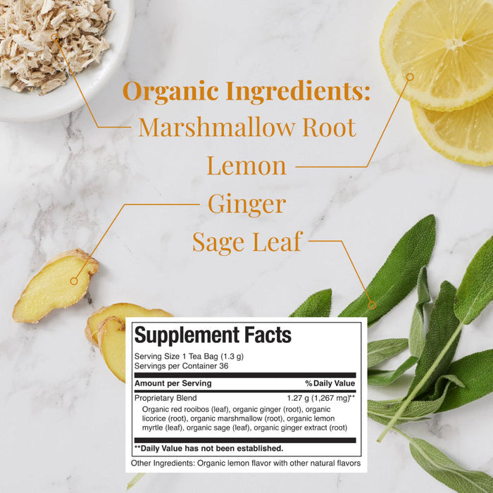 Supplement facts table with list of organic ingredients placed on a marble countertop next to marshmallow root, lemon slices, ginger slices, and sage leaves