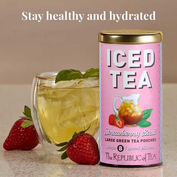 Pink can of 'Strawberry Basil' iced tea with a glass of iced tea and strawberries on a wooden surface.
